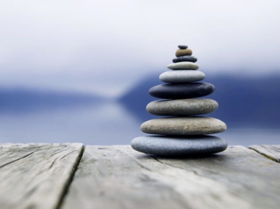 RE:ME Rebalance — stacked stones beside still water