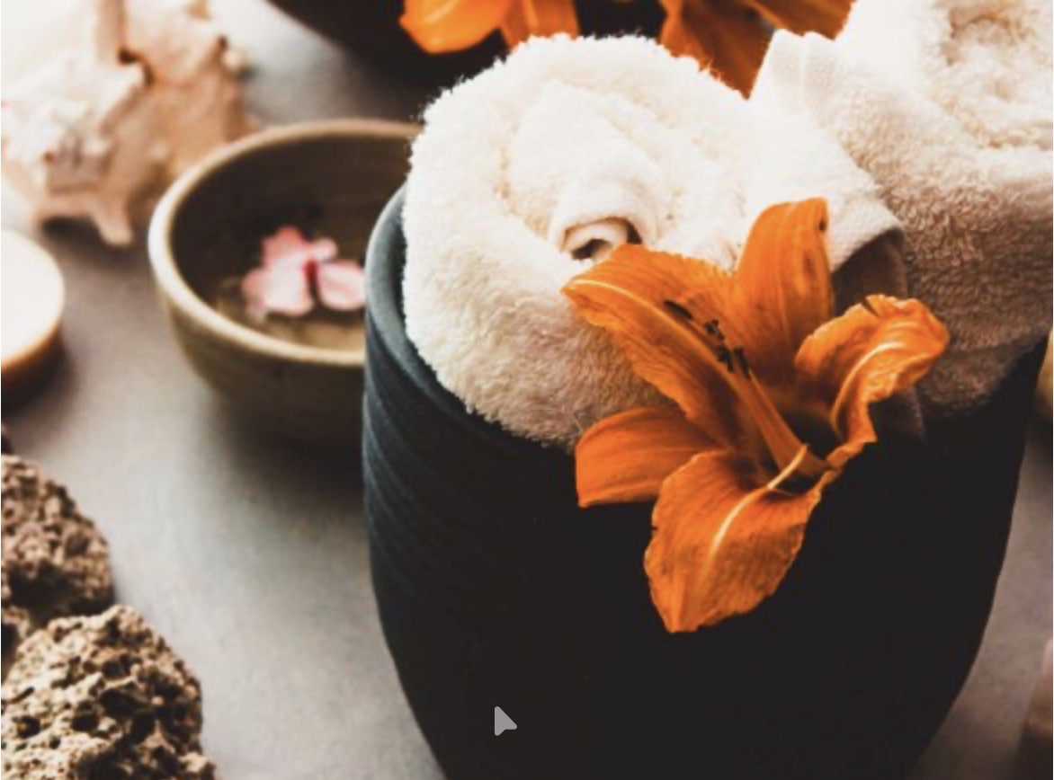 RE:ME Reset — rolled towels with an orange lily